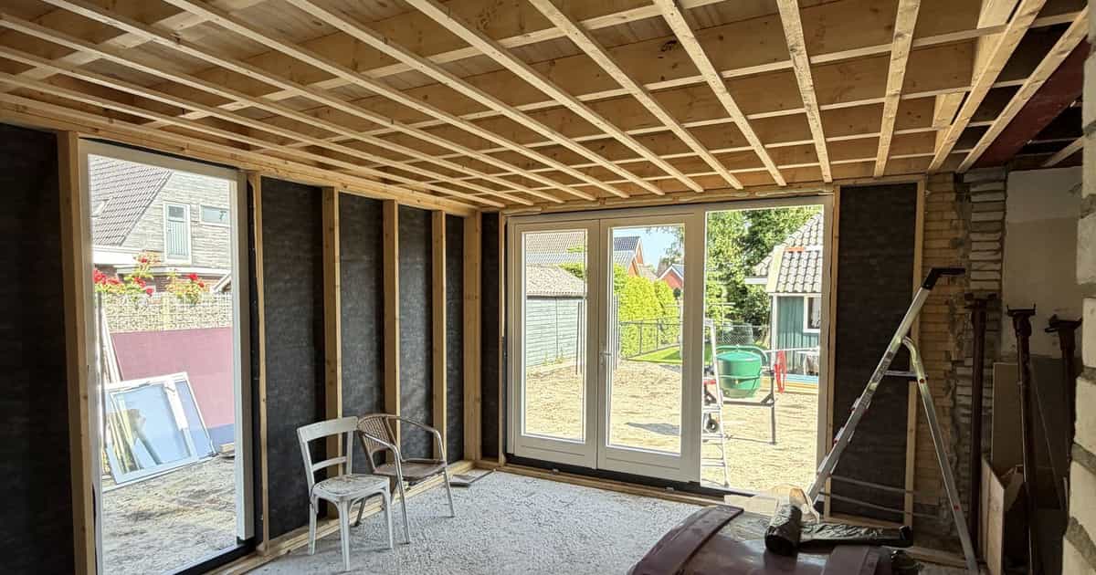 Binnenzijde van een aanbouw met tuindeuren tijdens de bouw in Buitenpost