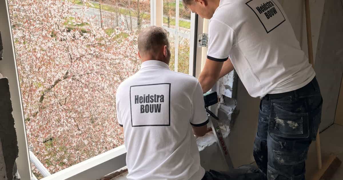 Medewerkers van Heidstra Bouw werken de aansluiting rond een raam af bij de woning aan de Dilgtweg in Haren